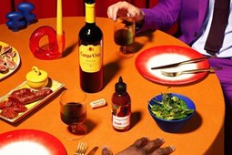 Bottle of wine and hot sauce on an orange table